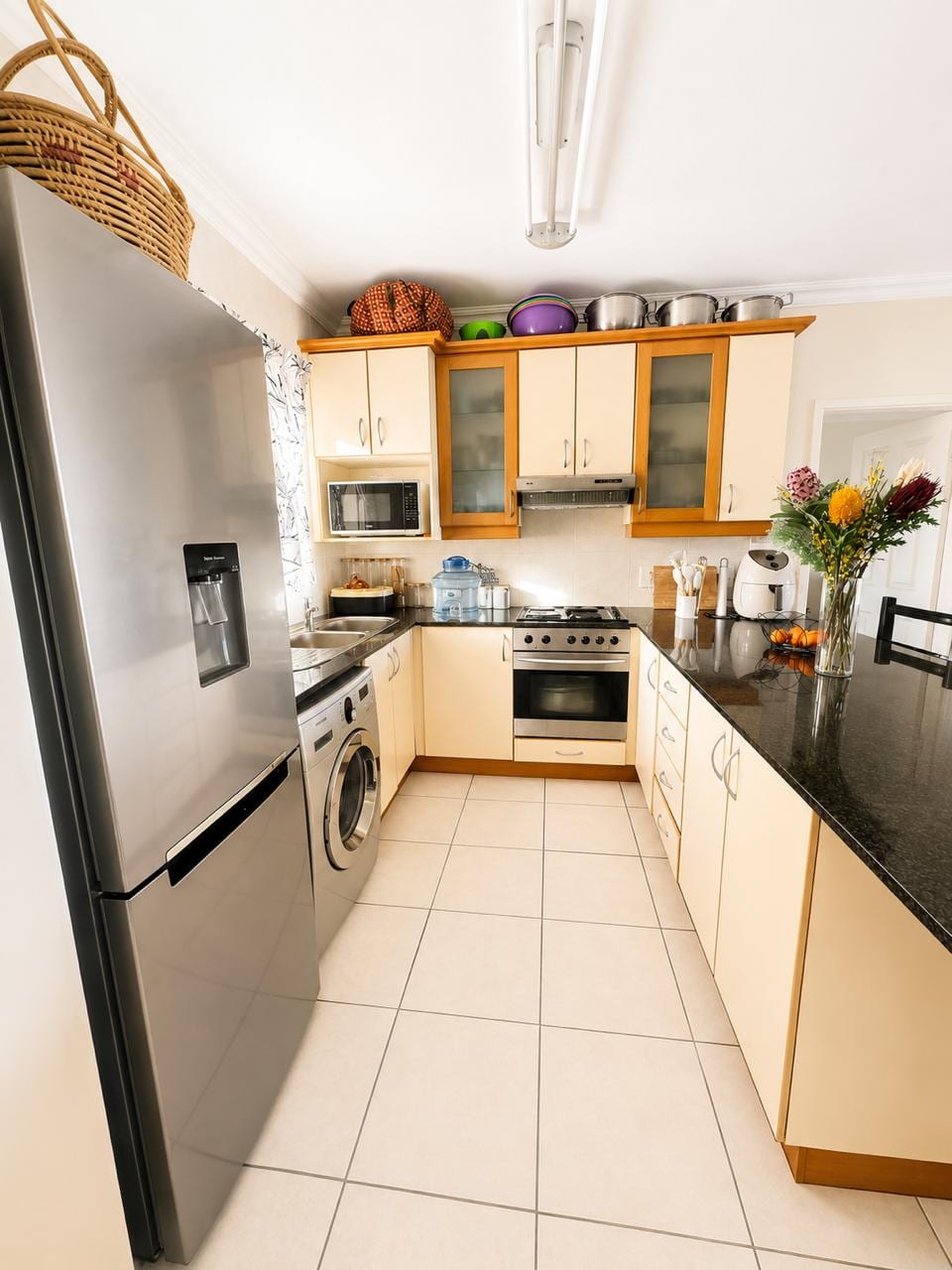The kitchen along its length, with full-height fridge and washing machine