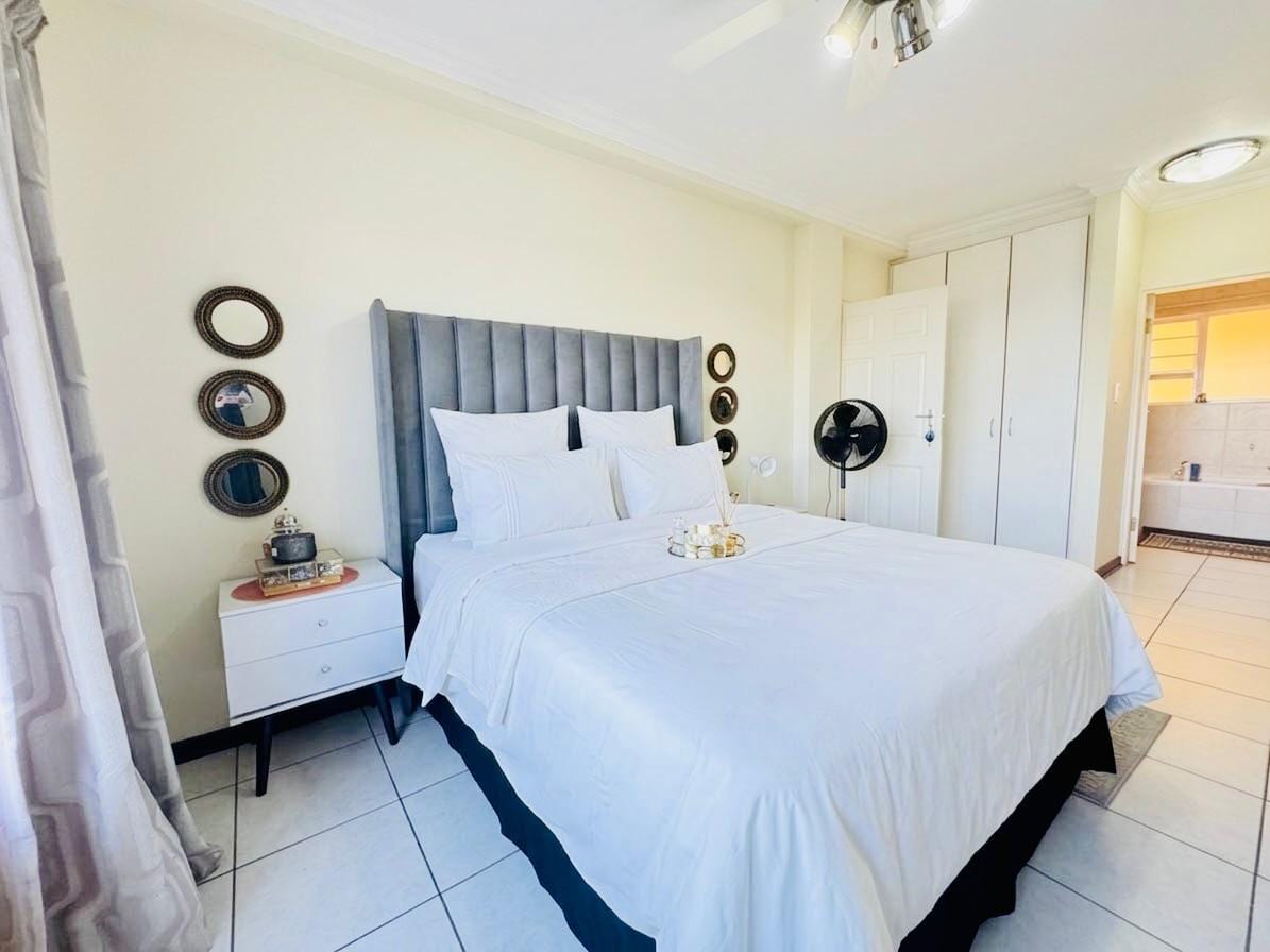 Bedroom with a king bed, upholstered headboard and built-in cupboards