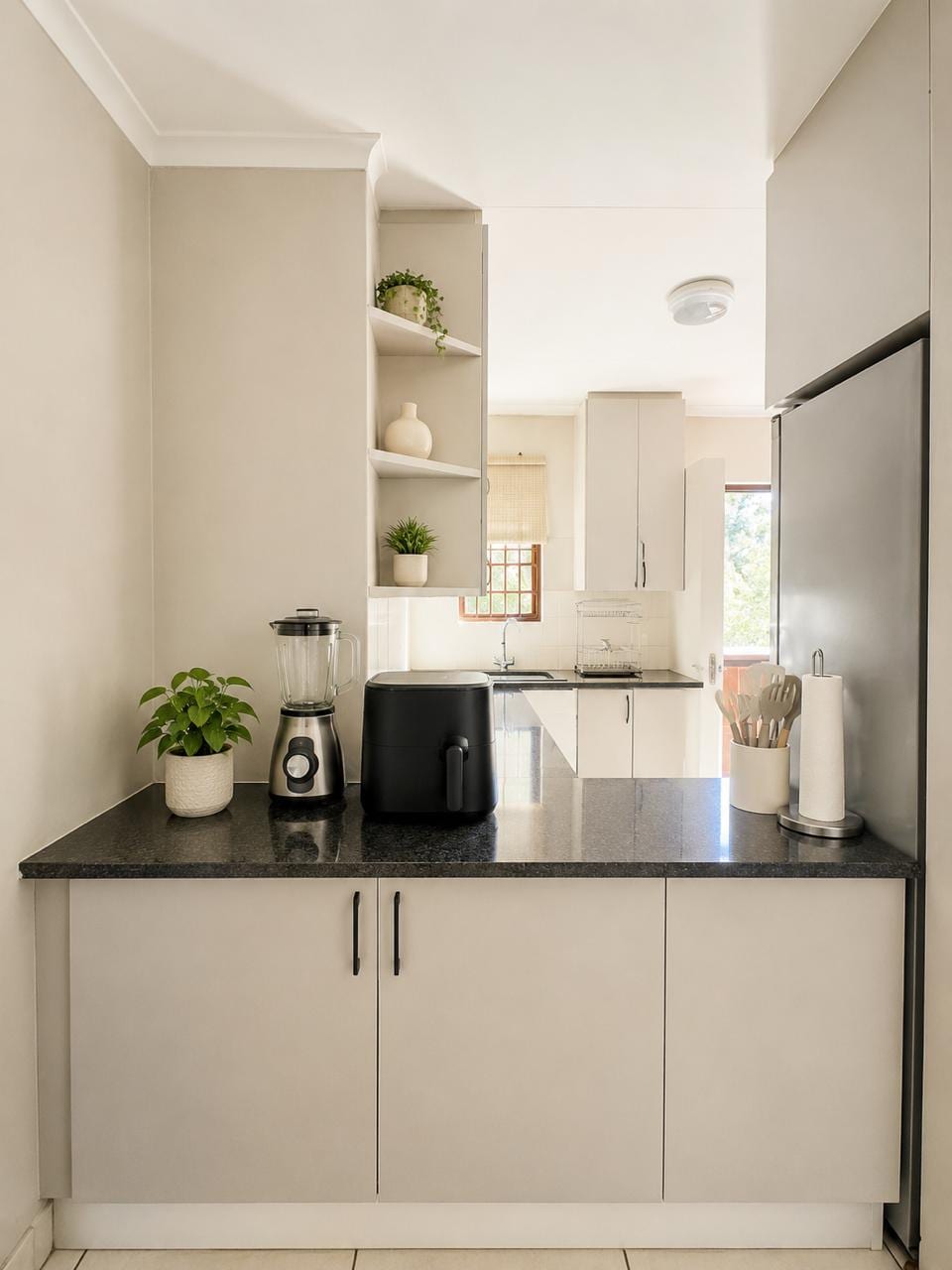 The kitchen from the other end, with built-in cupboards and open shelving