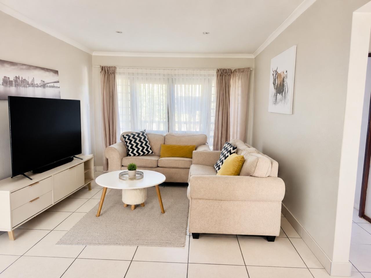 Open-plan living and dining room with sofa, low table and television