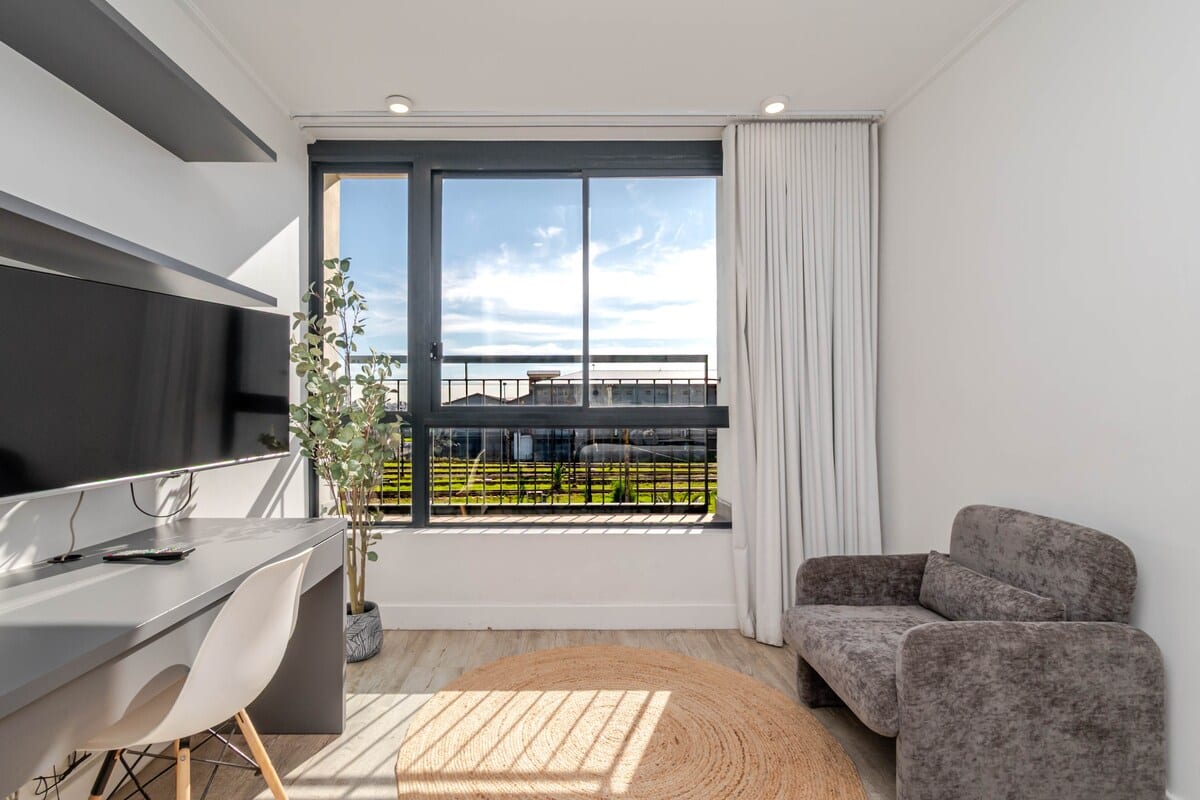 Workspace and armchair beside the window, looking onto the balcony