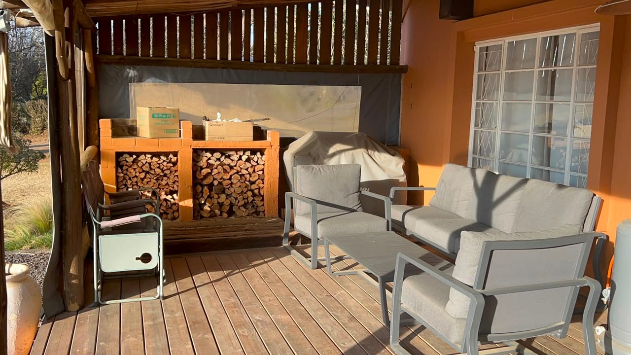 The covered deck, with stacked firewood and outdoor seating